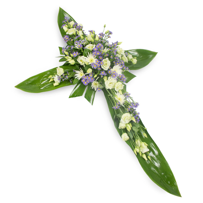 This solemn cross, photographed from a subtle overhead angle on a stark white background, reads as a studied composition: large, glossy tropical leaves - reminiscent of Ti leaves - are arranged to form the strong structural arms of the Christian cross, their smooth, veined surfaces creating a verdant frame. Concentrated at the centre and cascading along the principal axis are clusters of creamy ivory and soft white lisianthus, each bloom ruffled and layered with delicate petals that suggest shelter and tenderness. Among these, neat sprays of small white, daisy-like chrysanthemums add compact texture and a calm luminosity, while light lavender-hued limonium or small asters provide a cool, whispering contrast that deepens the palette without disturbing its serenity. Slender sprigs of fine green filler foliage weave through the flowers, bringing subtle movement and the faint scent of green stems and fresh leaves. The lighting is even and contemplative, bathing the arrangement in a quiet radiance that highlights both the waxy sheen of the leaves and the airy softness of the blooms. Crafted as a sympathy tribute for services, memorials, or church ceremonies, the piece conveys restrained compassion and enduring respect. Locally, this style of cross is often chosen for funerals held near hospitals, chapels, and community churches around Denmark Hill and Camberwell, where families seek a composed, spiritual expression of condolence that balances strength with tenderness.