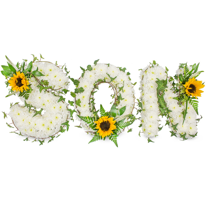 This artfully arranged sympathy piece spells SON in three substantial capital letters, each letter constructed from a thick carpet of small, immaculate white chrysanthemums that give the composition a soft, pillowed texture when seen close-up. The chrysanthemums' layered petals form a pristine backdrop against which trailing dark green ivy is woven - the ivy's glossy leaves curl and thread through the S, O and N, creating natural movement and an evergreen symbol of lasting bonds. Accenting the design are delicate fern fronds and slender leafy sprigs, which push up through the floral field to provide depth and varied greens across the letters. Bright, generous sunflowers add focal warmth: one rests on the upper-left curve of the S, another is settled low in the centre of the O amid fronds, and a third punctuates the upper-right portion of the N. Each sunflower's golden rays frame a textured, dark brown heart, drawing the eye and suggesting a light-filled memory within solemn tones. The entire arrangement was photographed against a stark white studio background with soft, directional light that preserves the white chrysanthemums' subtle shadows and the sunflowers' tactile detail. As a local florist who knows Denmark Hill, Camberwell Grove and the nearby Herne Hill community, I picture this tribute standing quietly at a service or placed at a graveside, conveying respect, love and a gentle sense of hope.