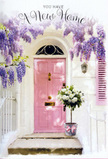 This evocative doorway scene, reminiscent of a lovingly restored home near Denmark Hill station or the leafy paths by Ruskin Park, frames the moment of arrival at a new address with floral poetry. The focal point is a pale pink front door that seems to glow softly, its colour gentle rather than loud, hinting at a calm, welcoming interior just beyond. Flanking and crowning the door, cascades of wisteria fall in layered curtains of lavender blooms, some clusters hanging low enough to almost brush the step, creating a dreamy archway of colour and fragrance. The walls around the entrance are whitewashed and slightly textured, catching stray beams of sunlight that dance faintly across the shutter and door, while shadows from the wisteria branches add depth and movement. On the doorstep sits a neat, grey metal bucket, its surface simple and slightly matte, holding a luxuriant bouquet of white and cream roses. Each rose is open and full, revealing rosettes of petals that look soft to the touch, interlaced with tender green foliage that peeks between the blooms. A soft pink ribbon is tied around the bucket's base, knotted in a tidy bow, its trailing ends echoing the pastel tones above and adding a finishing flourish. Though the street itself is unseen, the atmosphere carries the quiet excitement of moving into a new home in Denmark Hill-a blend of nerves, joy, and gratitude. The composition, with its soothing colours and gentle textures, feels perfect for a housewarming gift, expressing a heartfelt 'welcome home' through flowers alone.