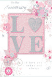 This romantic anniversary card is a gentle celebration of enduring love, its colours and textures as soft and intimate as a quiet walk through Denmark Hill at dusk. The centrepiece is the word LOVE, crafted in raised, softly shimmering glitter that gives each letter a dimensional, almost cushiony feel, inviting a tender touch. The O is replaced by a small, radiant heart, textured in silver that glints like a charm on a bracelet, reinforcing the theme of deep affection. Around this, an airy arrangement of delicate blossoms in blush, mauve, and powdered pink unfolds in a style that feels part watercolour, part fine-line illustration-very much like the romantic bouquets often requested for local anniversary deliveries. The petals are carefully shaded, giving them a velvety softness, while slender, curling stems and vines weave between them, adding movement and grace, reminiscent of the natural curves seen in hand-tied arrangements from a Denmark Hill florist. Subtle butterflies and tiny swirling flourishes appear here and there, suggesting lightness, hope, and the ongoing journey of two people growing together. The background washes the design in gentle pastel tones and silvery greys, creating a sense of privacy and treasured intimacy. Elegant script carries the words On Our Anniversary and I love you today and always, the lettering refined yet heartfelt, as if written by hand before being printed. The overall impression is of a thoughtfully crafted keepsake, perfect to tuck alongside an anniversary bouquet delivered to homes around Ruskin Park, down Grove Lane, or across the wider SE5 neighbourhood.